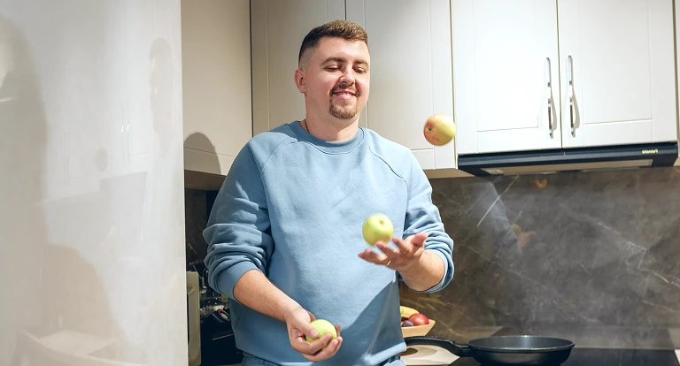 man juggling apples